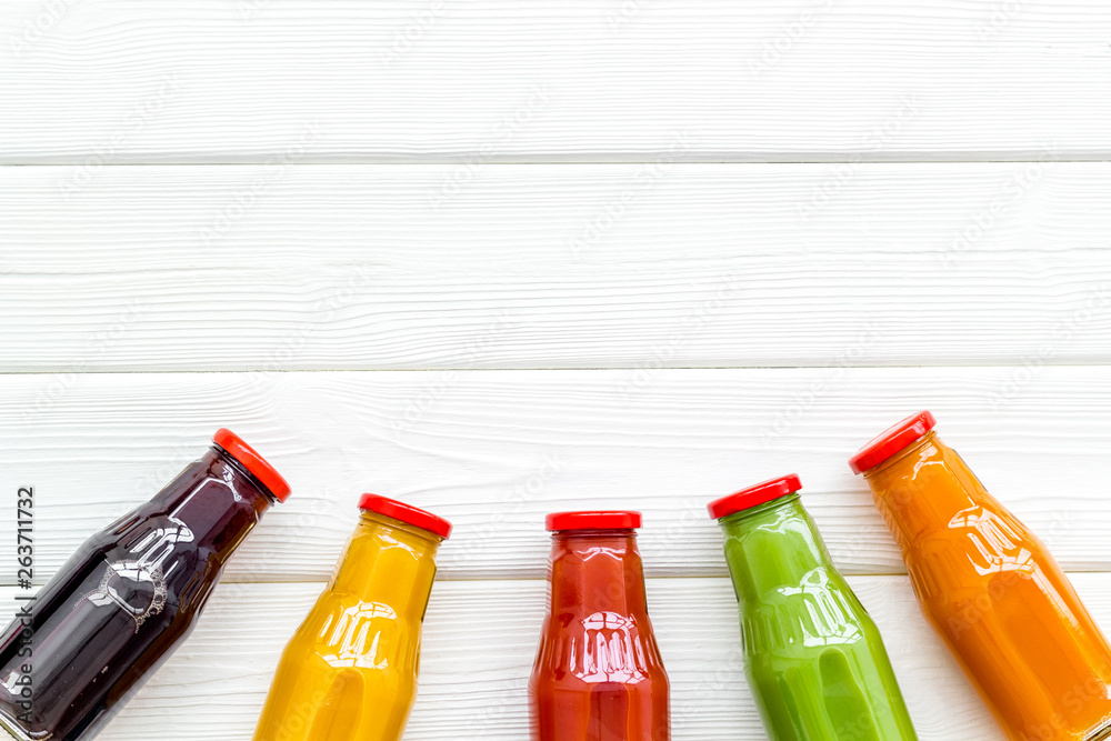 fresh organic juices in bottles for fitness diet on white wooden background top view mock-up