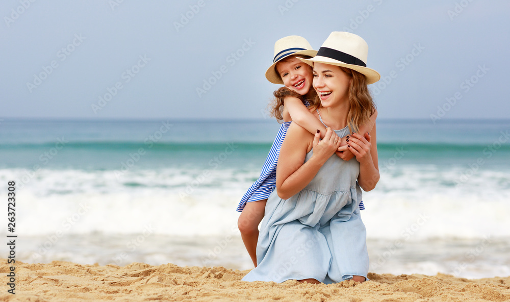 happy family at beach. mother and child daughter hug at sea