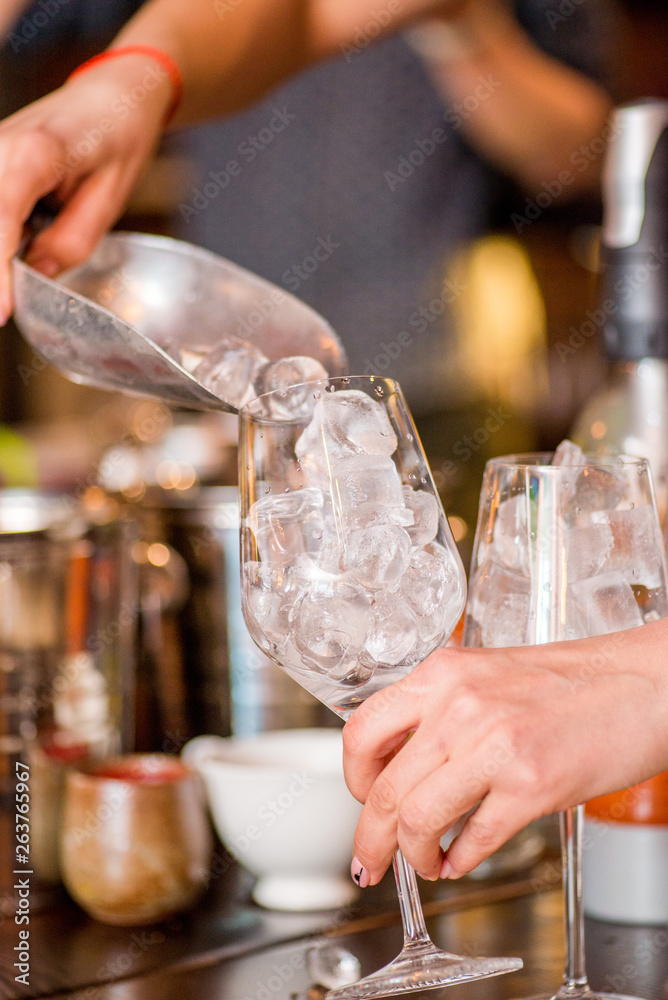 female bartender preparing aperol cocktail in a cocktail bar