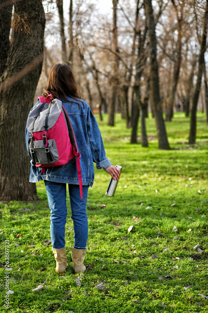 Woman with thermos traveling in forest