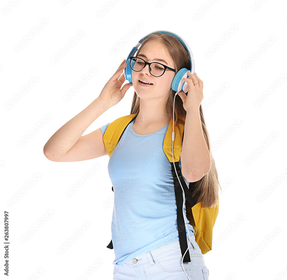 Cute teenage girl listening to music on white background