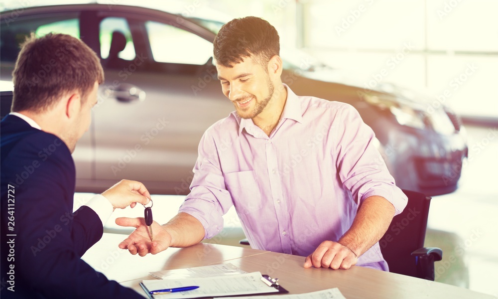 Happy man with car dealer in auto show or salon