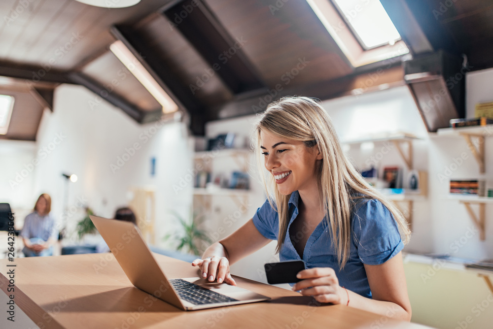 Happy young woman doing e-shopping.