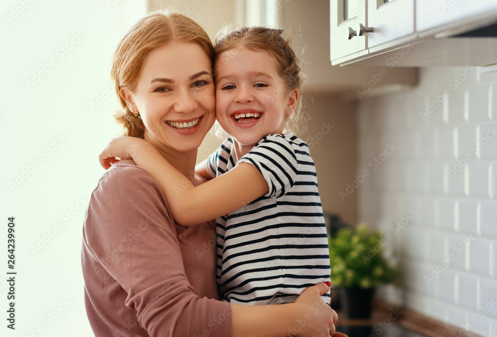 family mother and child daughter hugging in kitchen  .