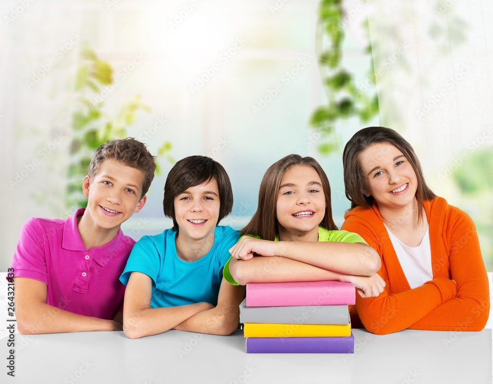 Happy children sitting by the table during lesson