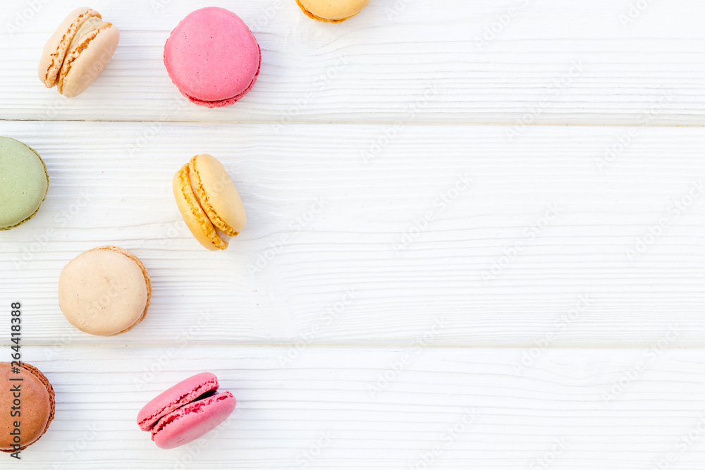 Macarons dessert pattern on white wooden background top view copy space