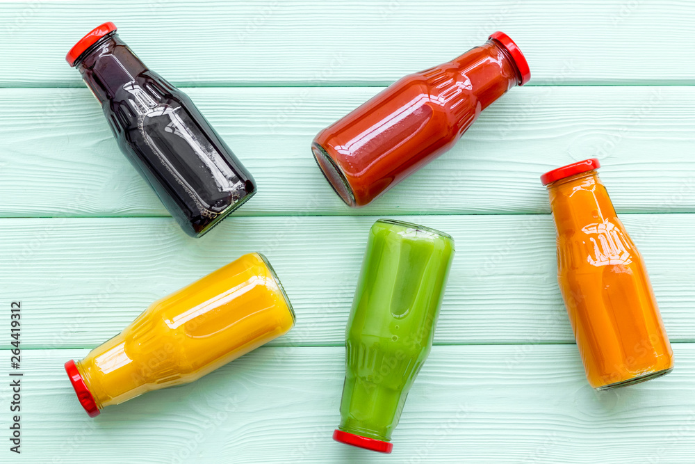 vegetable and fruit juice in bottles for diet drink on green wooden background top view mock up