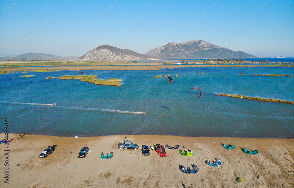 航空：在一个阳光明媚的夏日，体育游客沿着平静的海面风筝冲浪。