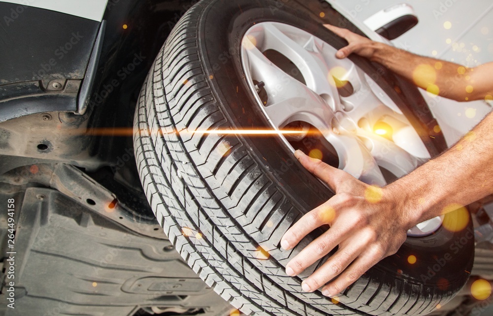 Male hands with Automobile tires on background