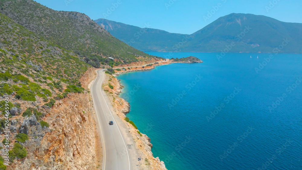 无人机：沿着道路行驶的汽车周围环绕着风景如画的地中海景观。