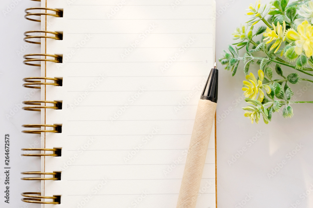 Blank notebook paper and pen on white marble background, with copy space for text, top view