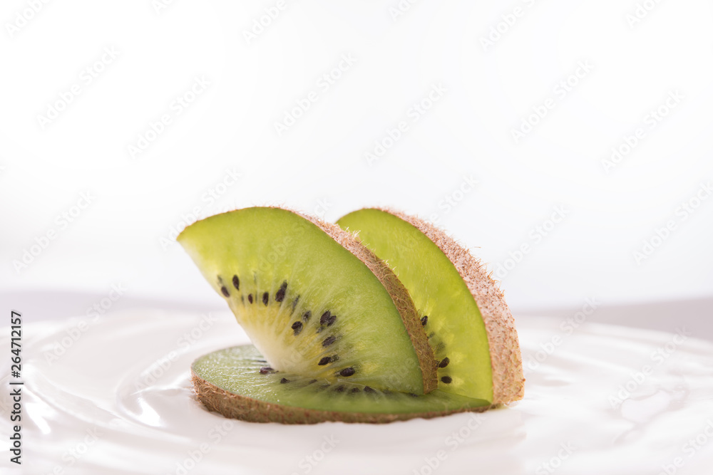 Plain yogurt with fresh kiwi fruit on top in bowl isolated on white background