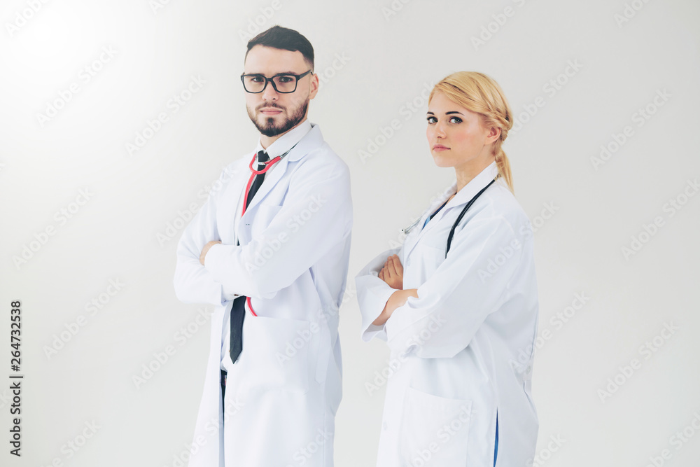 Confident doctors standing on white background with arms crossed. Concept of professional medical he