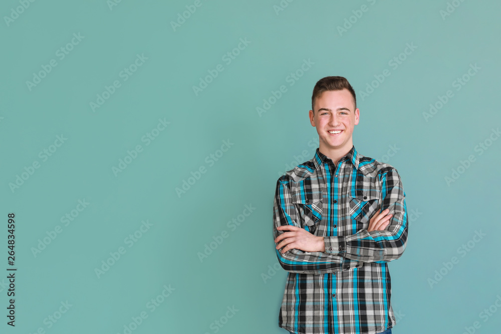 Cute teenage boy on color background