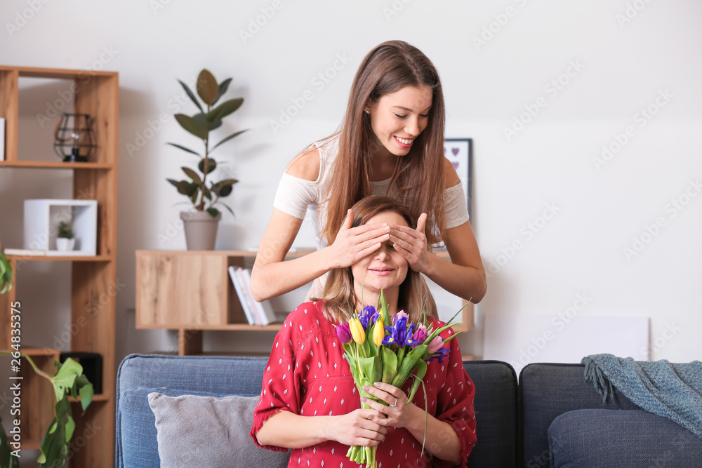 女儿在家里用鲜花问候母亲