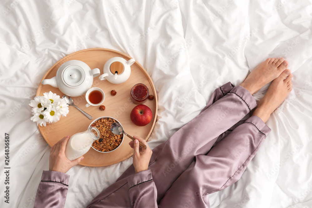 Woman having tasty breakfast in bed