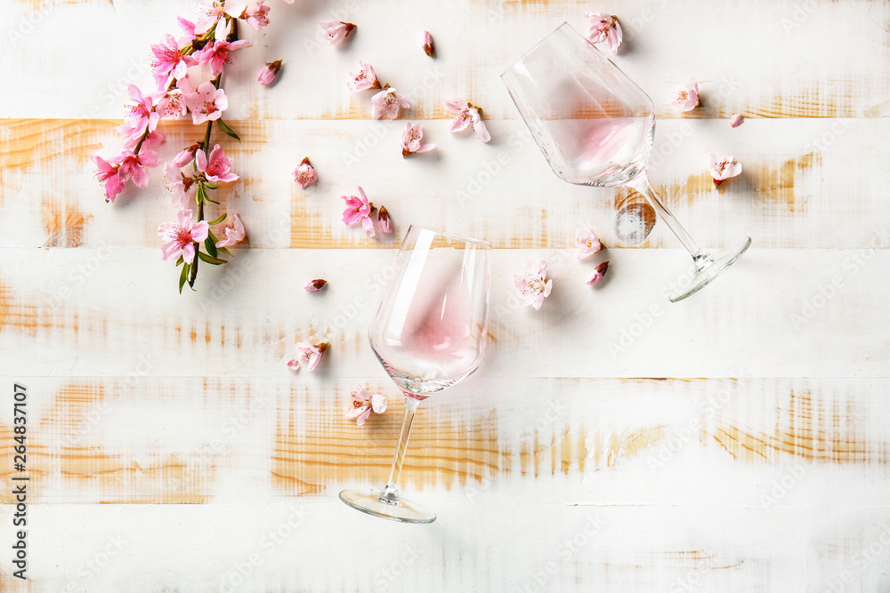 Beautiful blooming branch and empty glasses on wooden table