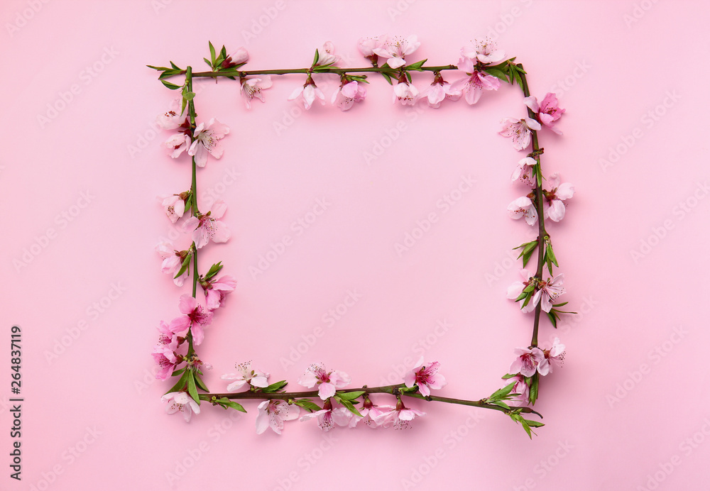 Frame made of beautiful blooming branches on color background