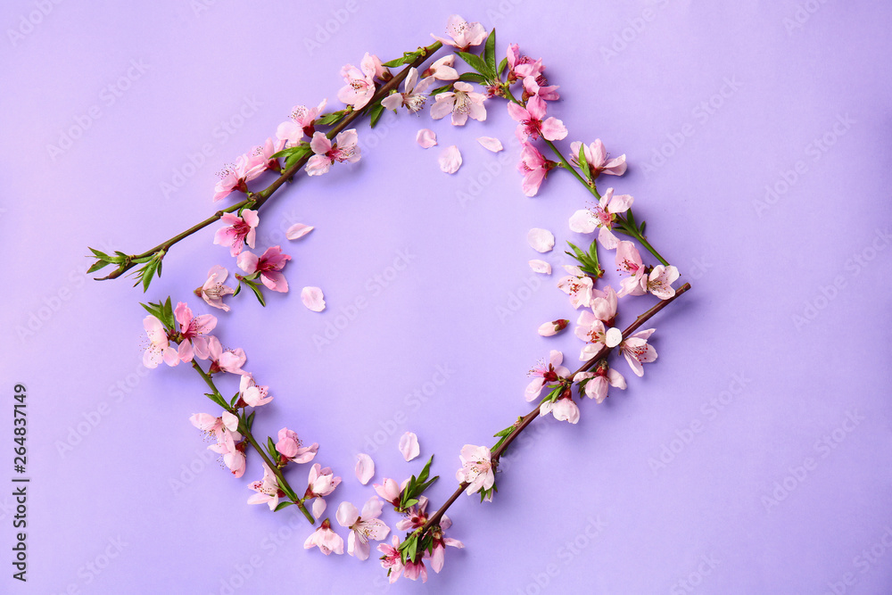 Frame made of beautiful blooming branches on color background