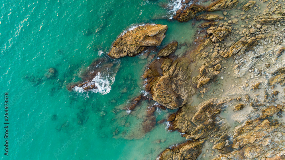 Aerial view drone shot of seascape scenic off beach in phuket thailand with wave crashing on the roc