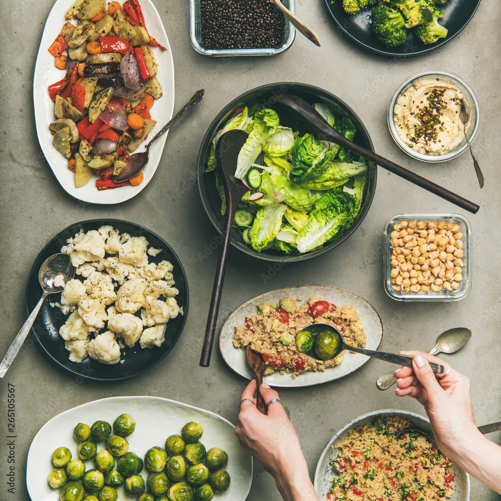 Vegan dinner table setting. Healthy dishes in plates on table. Flat-lay of vegetable salads, legumes