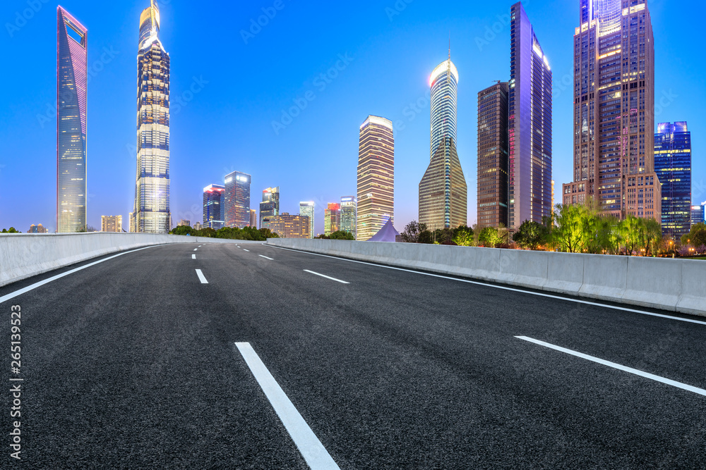 Shanghai modern commercial office buildings and empty asphalt road at night,panoramic view