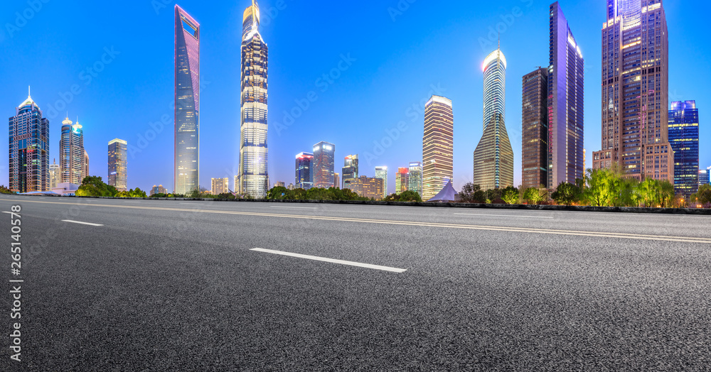 Shanghai modern commercial office buildings and empty asphalt road at night,panoramic view