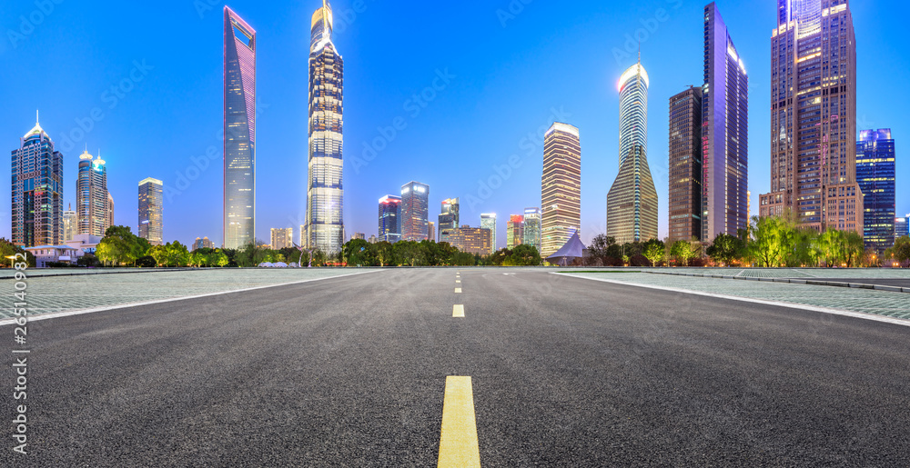 Shanghai modern commercial office buildings and straight asphalt road at night,panoramic view