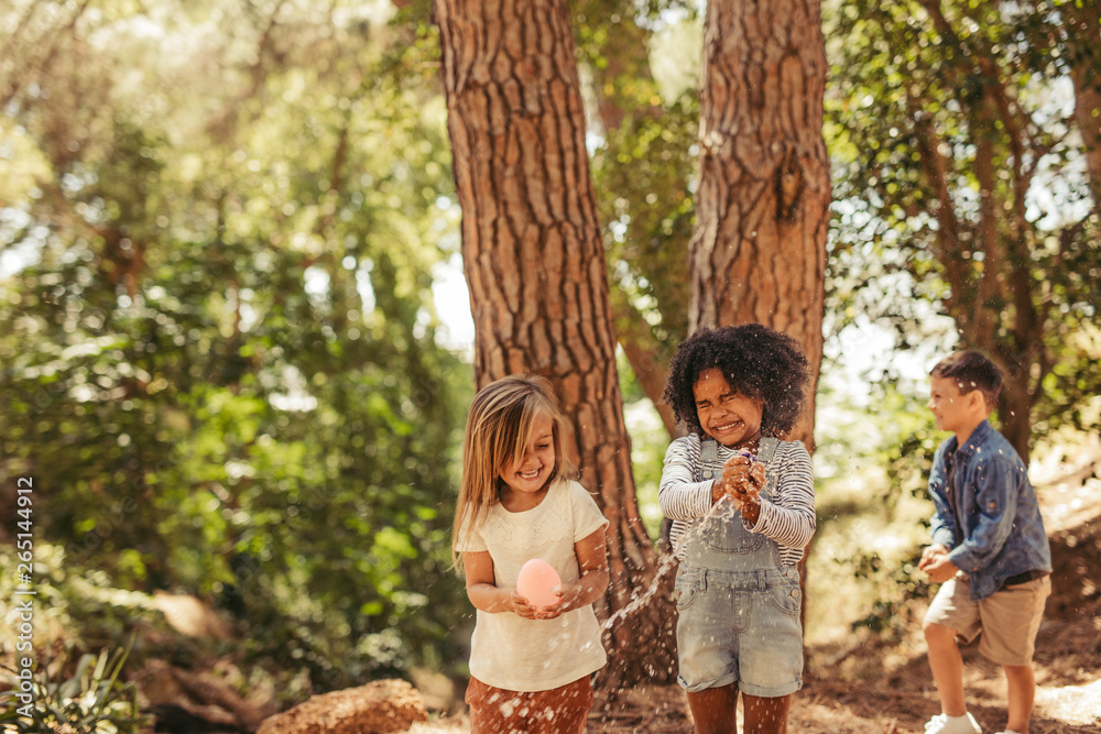 Kids playing with water balloon in park