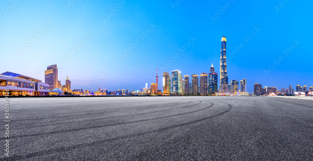 Asphalt race track ground and modern skyline and buildings in Shanghai at night,panoramic view