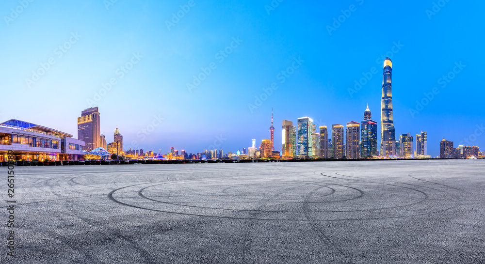 Asphalt race track ground and modern skyline and buildings in Shanghai at night,panoramic view