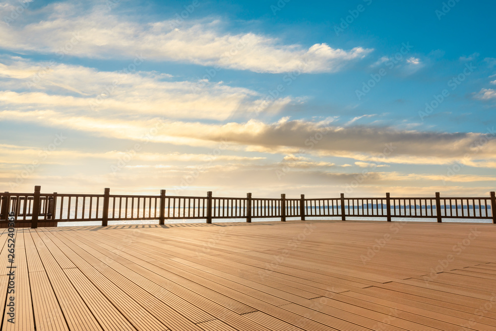 Lakeside wood floor platform and sky clouds at sunset