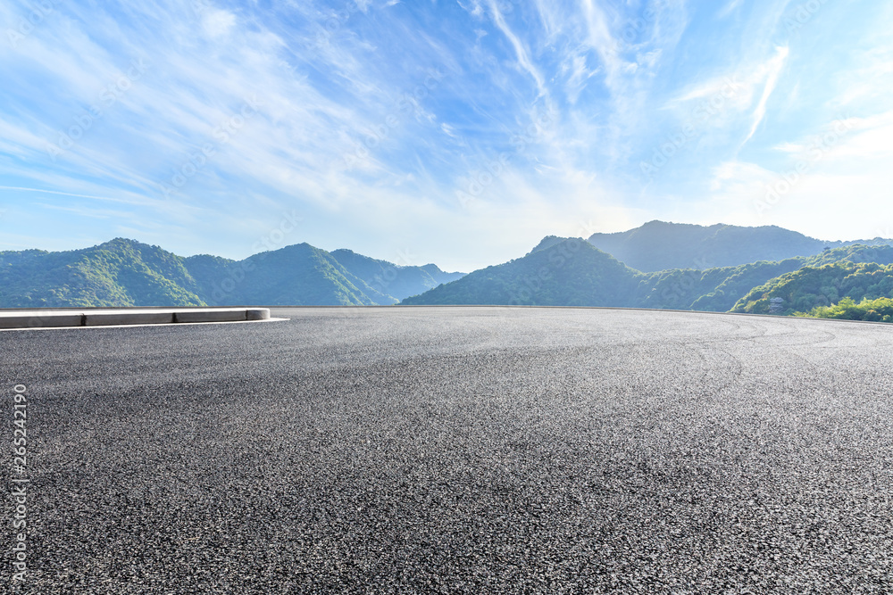 Parking lot pavement and green mountains natural landscape under the blue sky