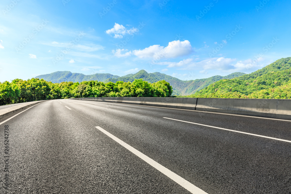 Country road and green mountains natural landscape under the blue sky