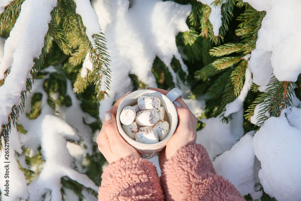 Woman with cup of hot cacao outdoors