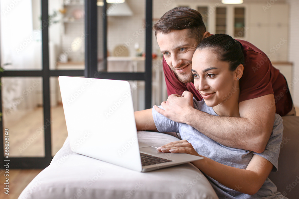 Happy young couple with laptop at home