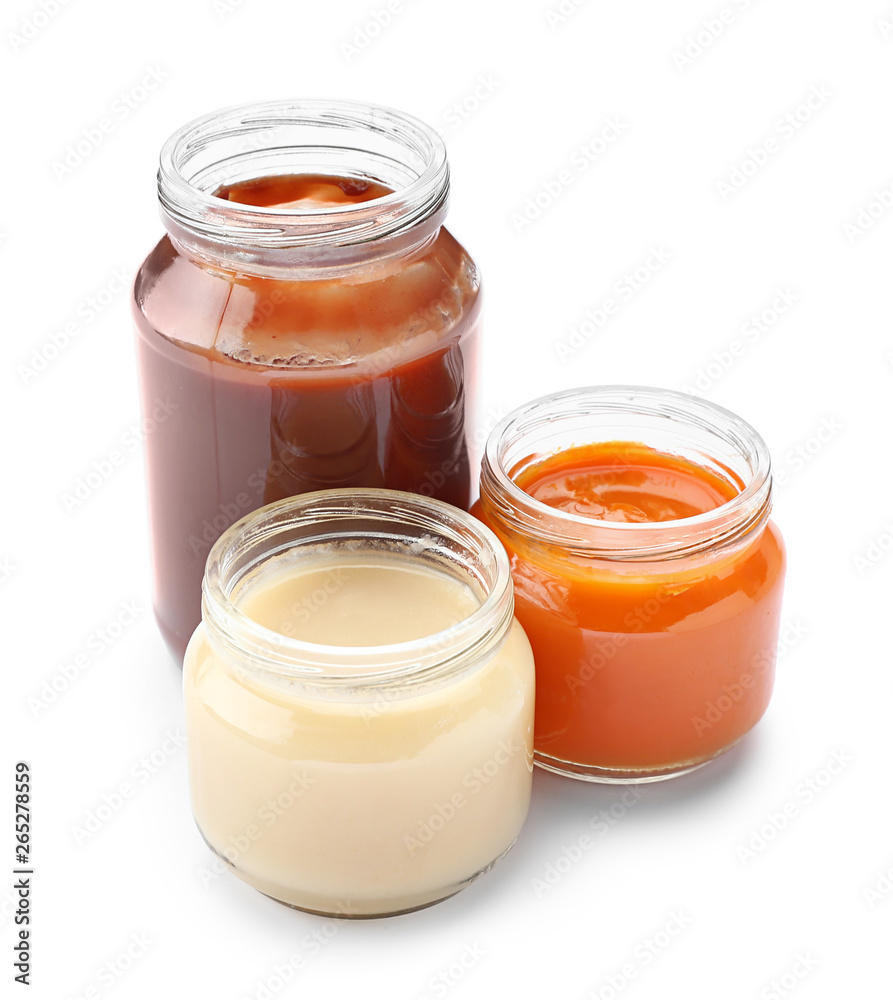 Jars with different healthy baby food on white background