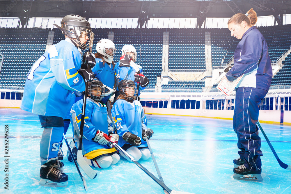 Hockey players listening to coach during training