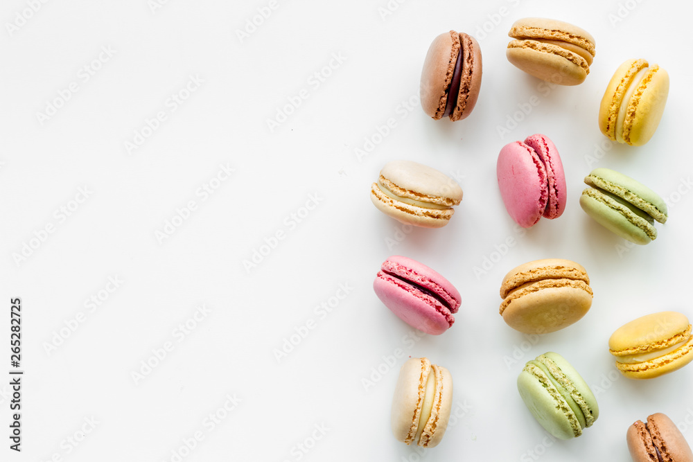 Brignt macarons for sweet break on white background top view mock up