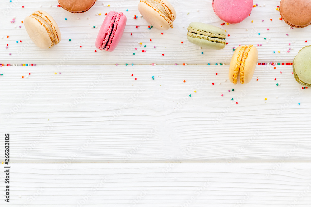 Macarons design on white wooden background top view space for text