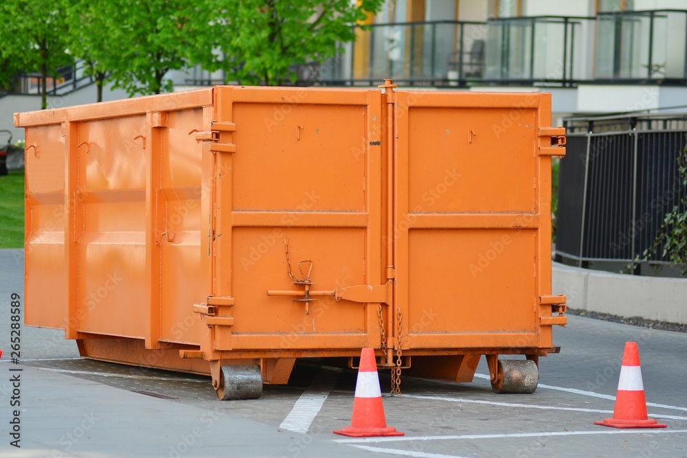 Orange colored dump bin at open space