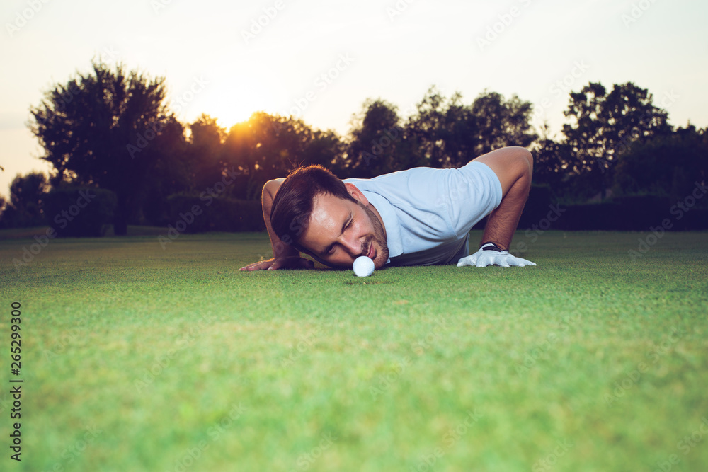 Golfer checking line of putt on green 