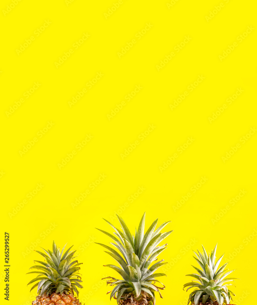 Creative pineapple looking up with sunglasses and shell isolated on yellow background, summer vacati