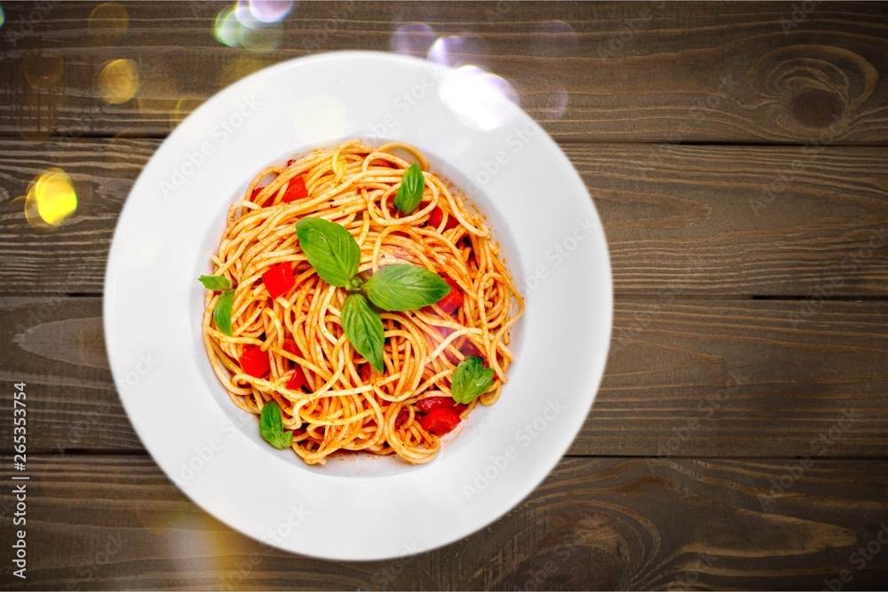 Spaghetti pasta with tomatoes and parsley on  table.