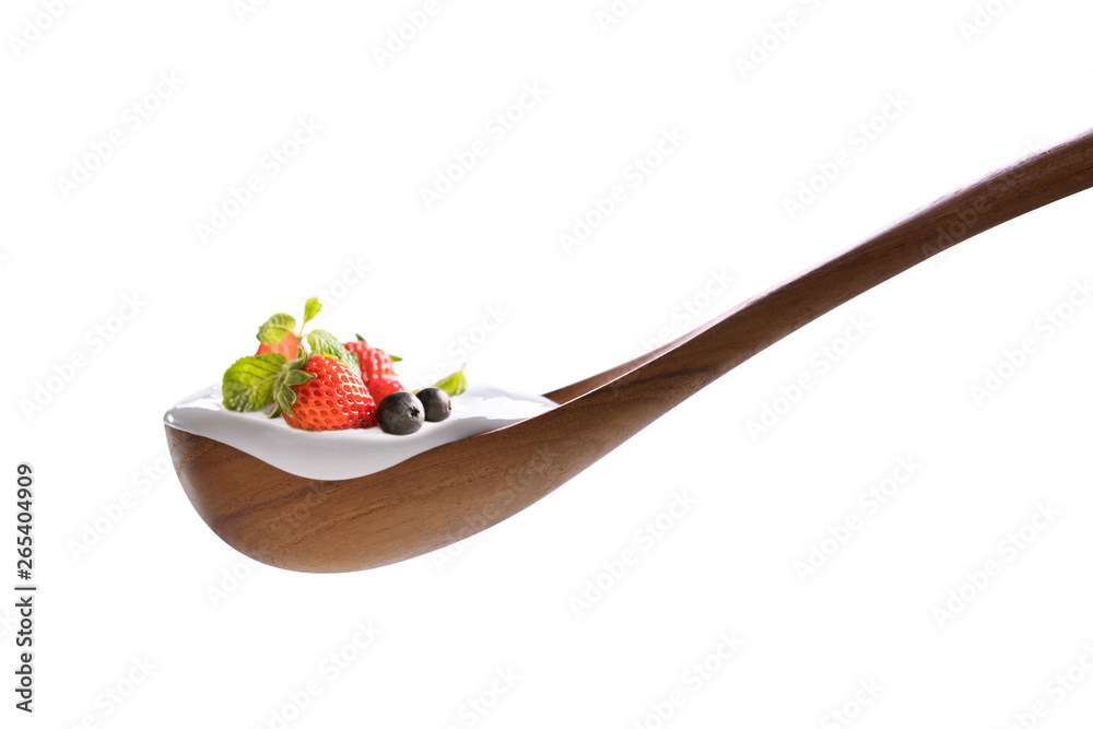 Plain yogurt on a spoon with fresh berry fruits on top isolated on white background