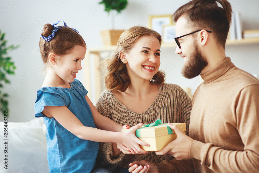 Happy fathers day! family mom and daughter congratulate dad and give gift      .