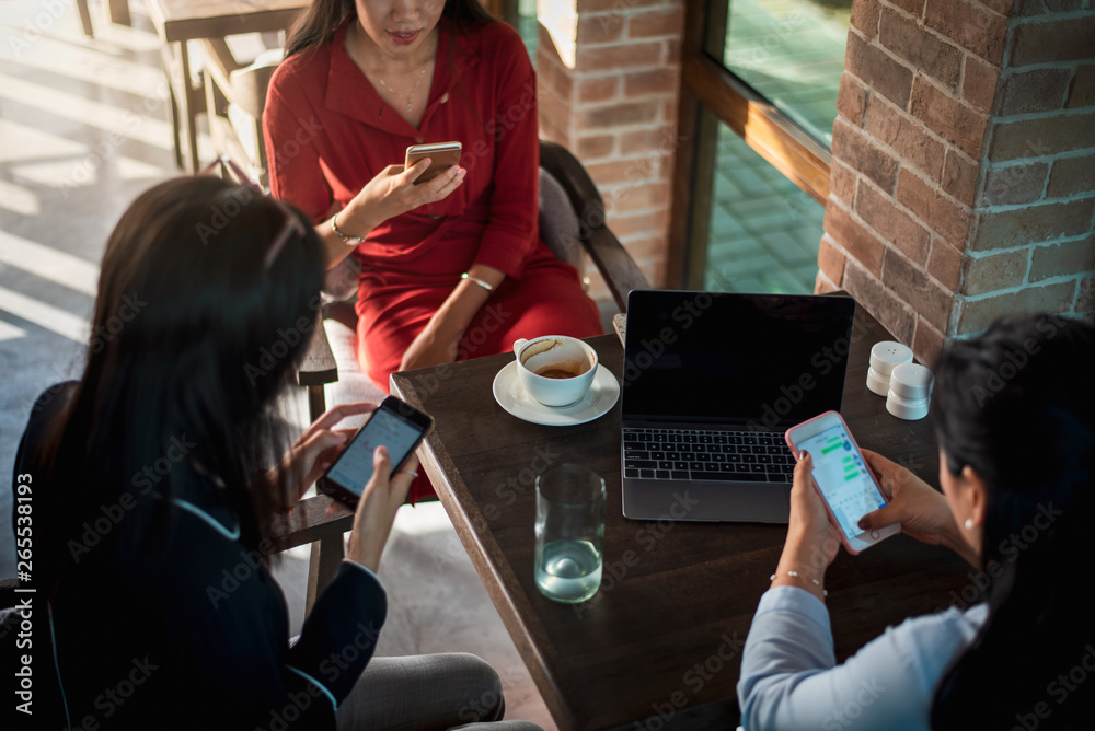 Women using phones in a bar