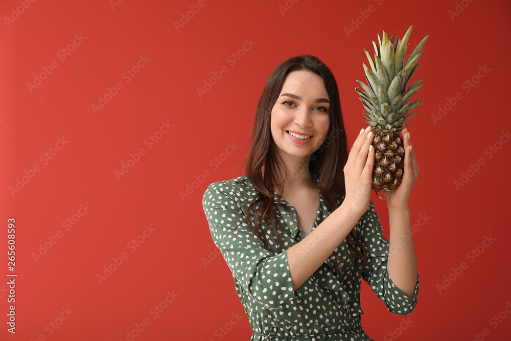 Beautiful young woman with fresh pineapple on color background