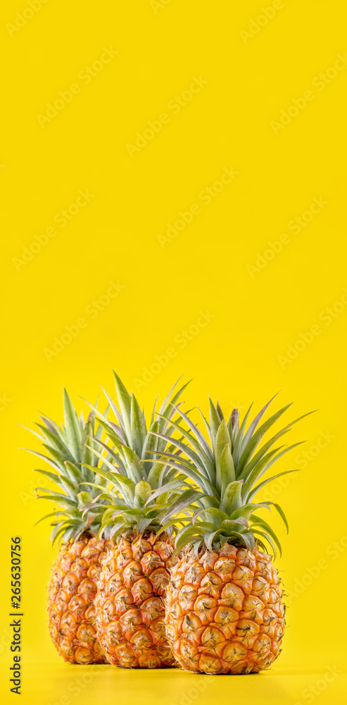 Beautiful fresh pineapple isolated on bright yellow background, summer seasonal fruit design idea pa