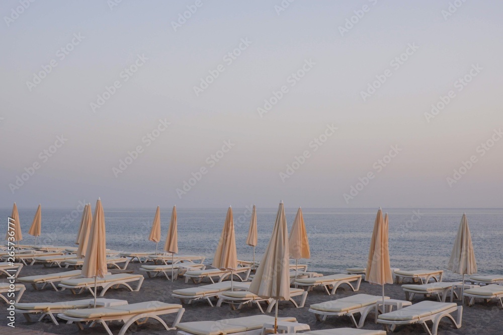 beach umbrella, beds, sand and the mediterranean sea. summer on the mediterranean sea, under blue sk